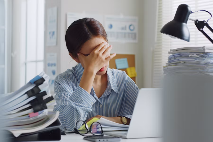 Person pinching bridge of nose, headache, muted light
